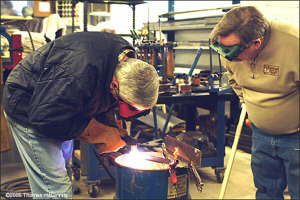 Joe Desimone de Simone makes his first cut, as Marshall Labow watches.