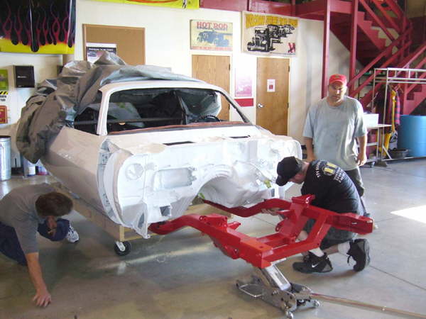 The newly powder coated subframe is bolted in the freshly painted body